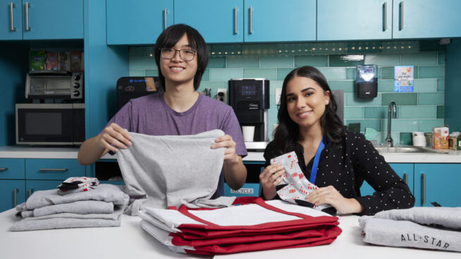 Two volunteers placing CBC blood donor giveaways in a bog.